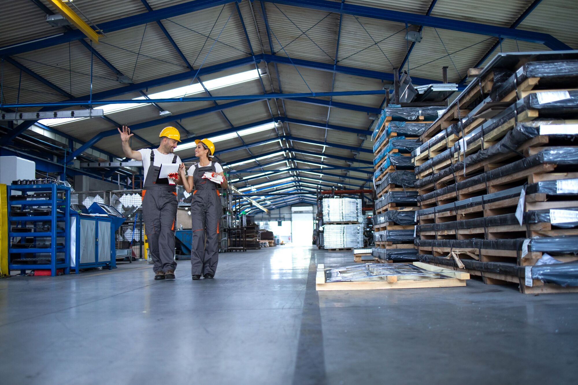 factory-workers-work-wear-yellow-helmets-walking-through-industrial-production-hall-sharing-ideas-about-organization (1)